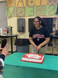 PASE Senior, Seidy Castillo, cutting the cake for her "Congratulations" party.